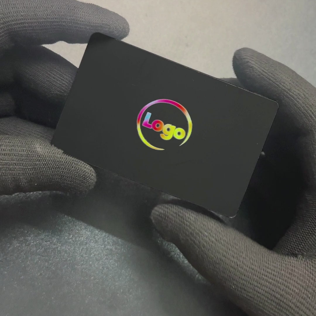 Black metal NFC card in gloved hands, then tapped on an iPhone, which shows the pop-up to open the TapSticky profile