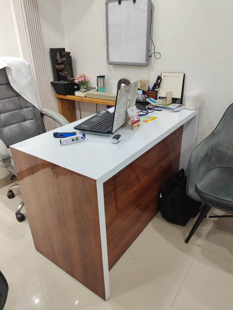 A clinic desk with a laptop, a stethoscope and thermometers, and the TapSticky review plate on a small easel